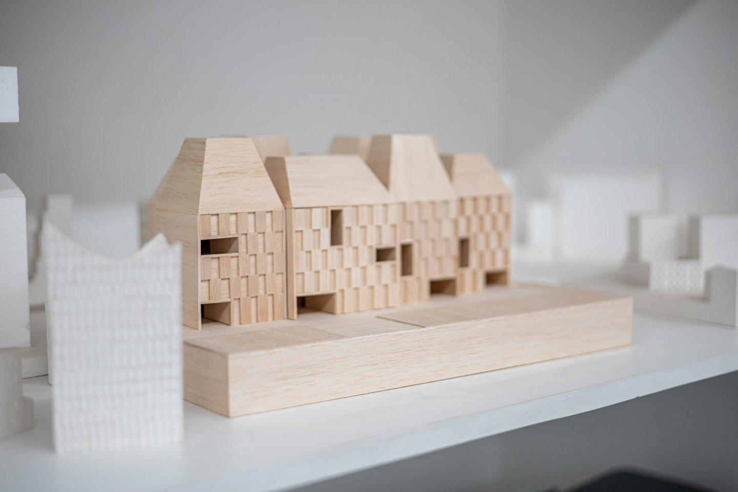 Wooden architectural model of a multi-unit building in studio.